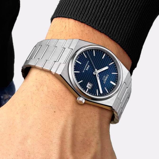 Reloj Tissot PRX azul con correa metálica visto en muñeca – imagen lifestyle elegante para hombre